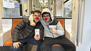 2 Schüler beim Spendensammeln in der Straßenbahn